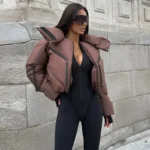 Stylish woman in puffer jacket and sleek black athletic bodysuit outdoors.